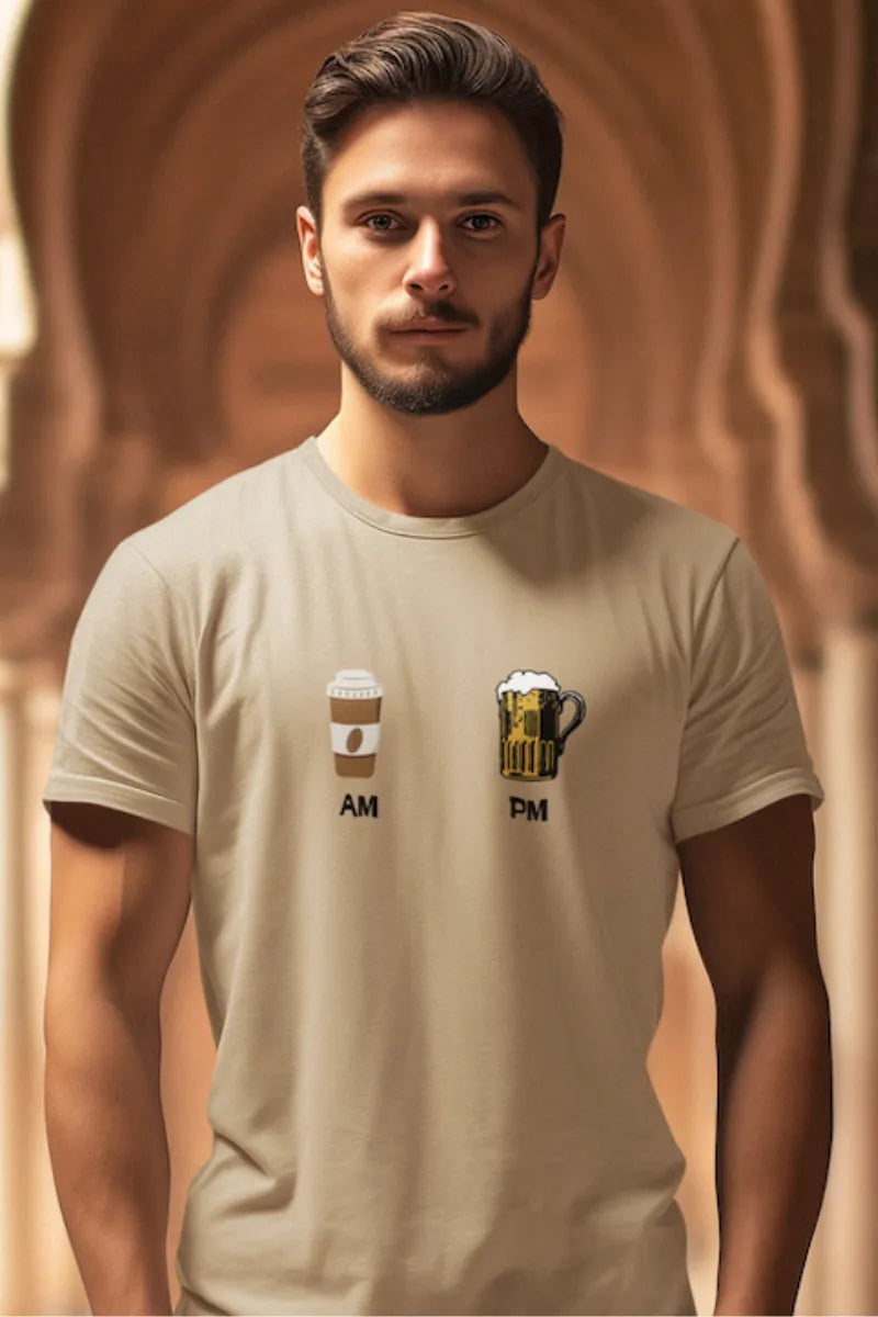 A man wearing a Beige brown t-shirt with AM-PM print showing coffee in the morning and beer at night, worn by a male model.
