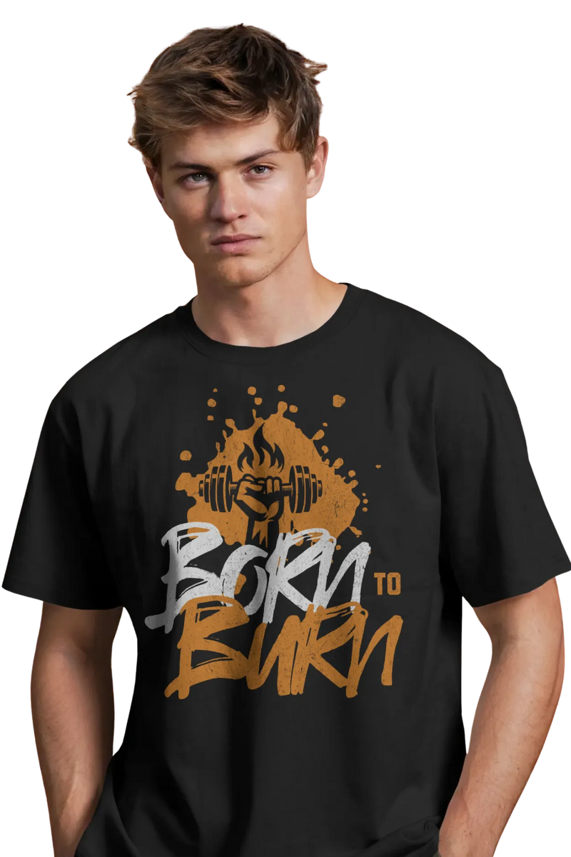 Young man wearing a black cotton t-shirt with "Born to Burn" graphic and a flaming dumbbell illustration, standing confidently with hands in pockets.