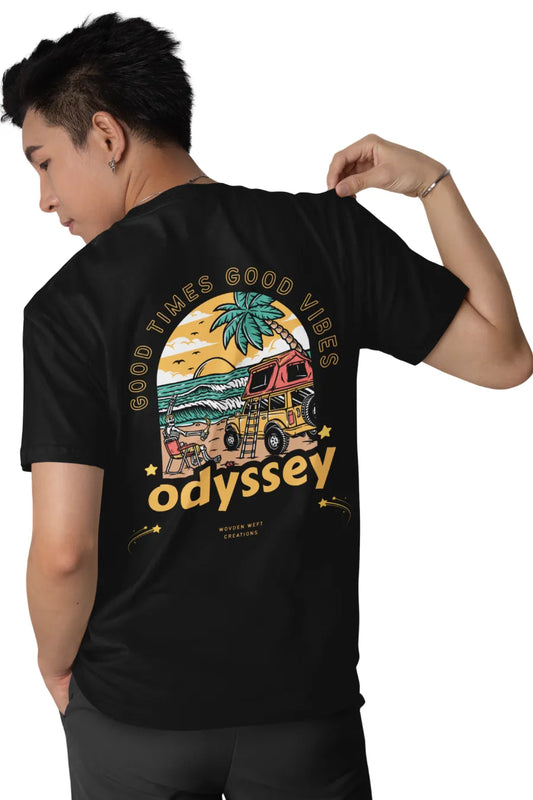 Man wearing a black double impact T-shirt with 'Good Times Good Vibes' text on front and colorful 'Odyssey' beach van graphic on back.