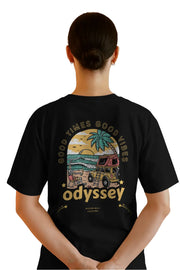 Back view of woman in black relaxed fit t-shirt with Odyssey beach van and sunset design