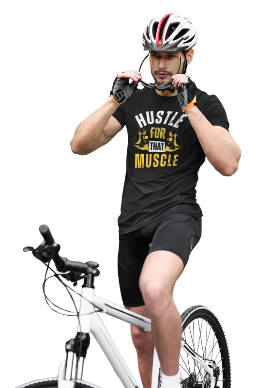 Man in black cotton t-shirt with “Hustle For That Muscle” quote in white and yellow, wearing cycling gear and sunglasses, seated on a white bicycle.
