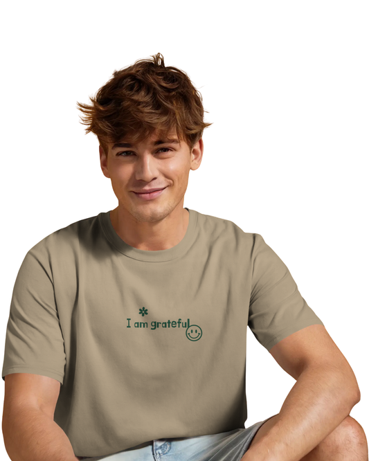 Man wearing a beige brown shade cotton t-shirt with green motivational quotes like “I am getting better every day” printed on the back and front in a fun layout.