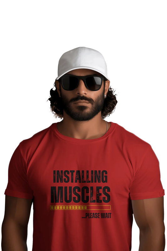 Man wearing red t-shirt with the quote “Installing Muscles Please Wait” and a loading bar design. Styled with white cap and black sunglasses.
