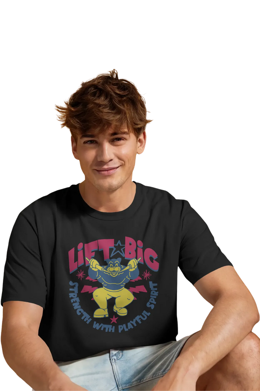 Smiling man wearing a black t-shirt with colorful cartoon design and quote “Lift Big – Strength with Playful Spirit” printed on the chest.