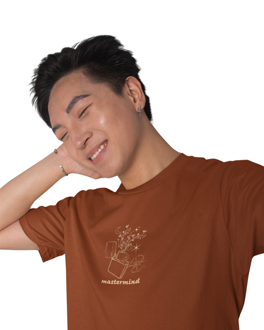 Man wearing rust brown cotton t-shirt with multiple playful quotes like “Snow on the Beach,” “Midnight Rain,” and “Karma” printed.