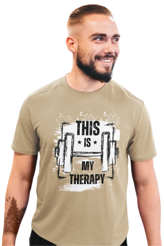 Man wearing beige brown shade t-shirt with bold quote “This Is My Therapy” and a sketched dumbbell design printed on chest.