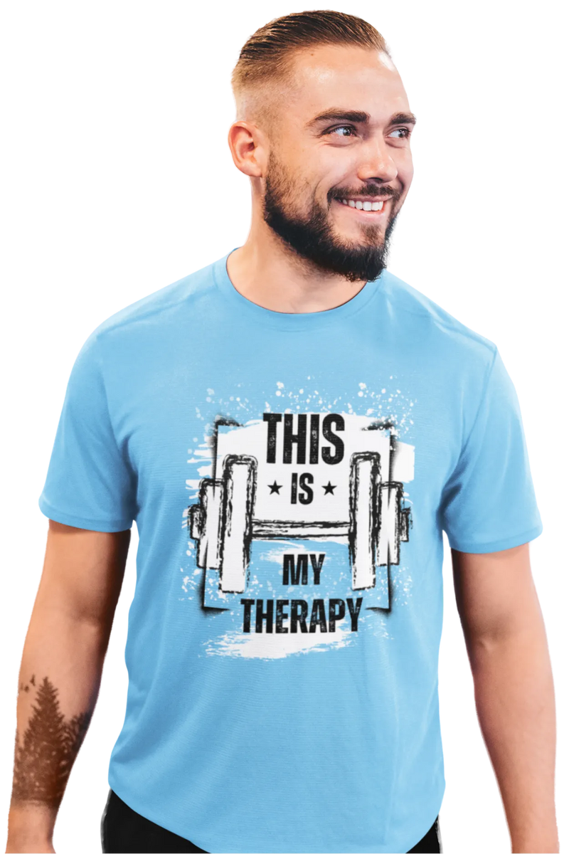Man wearing a sky blue cotton t-shirt with “This Is My Therapy” text and barbell graphic printed on the front, smiling confidently.