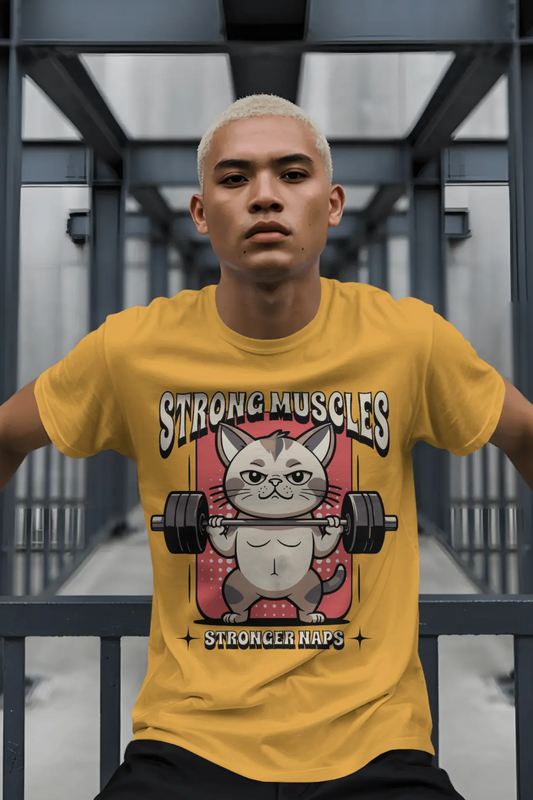 Man wearing a mustard yellow cotton t-shirt with a graphic of a cartoon cat lifting a barbell. Text on the t-shirt says “Strong Muscles, Stronger Naps.”