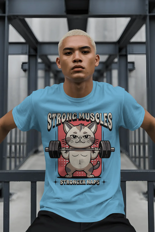 Man wearing a sky blue t-shirt with a cartoon muscular cat lifting a barbell. Text on the tee reads “Strong Muscles Stronger Naps”.