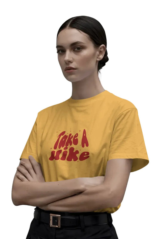 Woman wearing mustard yellow Take A Hike graphic T-shirt with arms crossed